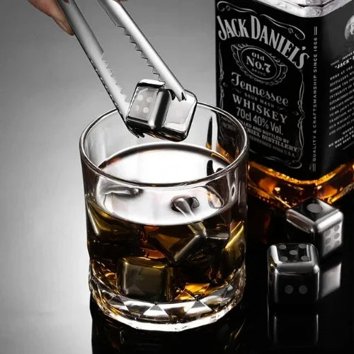 Pierre rafraichissante dans une pince à glaçon au dessus d'un verre de whisky