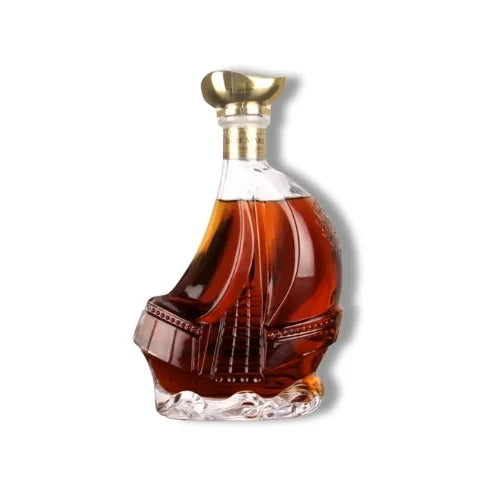 Carafe à whisky en forme de bateau avec bouchon doré et design élégant, remplie de whisky ambré.