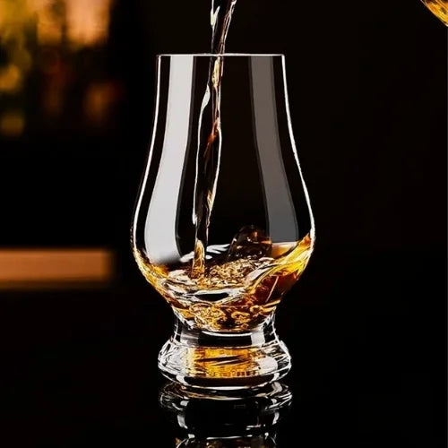 Le whisky se verse délicatement dans un verre Glencairn, illustrant une dégustation raffinée.