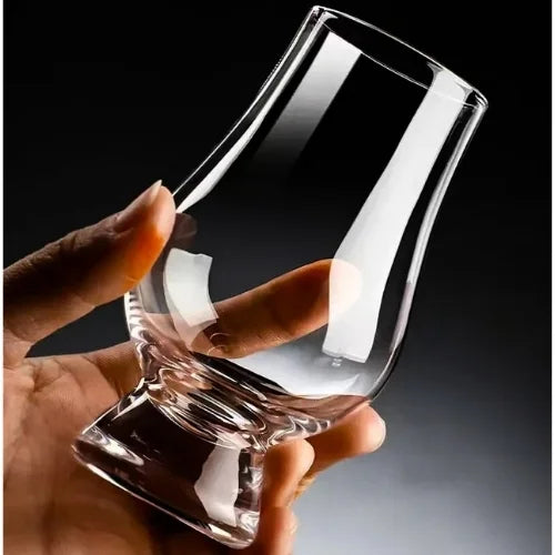 Le verre Glencairn tenu dans la main, révélant sa forme ergonomique et ses courbes élégantes.