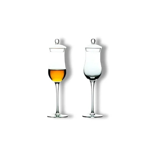 Deux verres à whisky avec couvercle en verre soufflé, l'un rempli d'ambre liquide et l'autre prêt à l'accueillir.