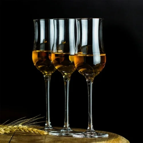 Trois verres à whisky avec couvercle, alignés sur une table en bois, parfaits pour sublimer vos meilleurs spiritueux.