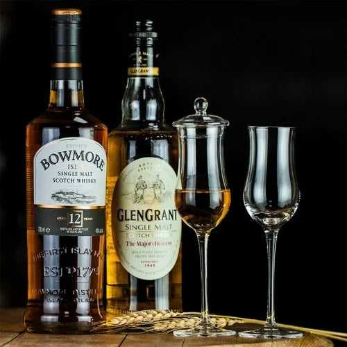 Un duo élégant de bouteilles de whisky accompagné de verres raffinés avec couvercle, pour une dégustation sophistiquée.