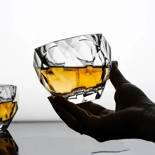 Le verre à whisky diamant en main, révélant son design fascinant et ses jeux de lumière.