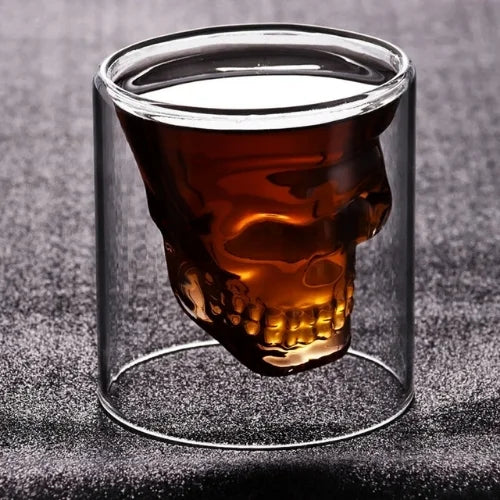 Rempli de whisky ambré, ce verre tête de mort révèle des détails saisissants qui captivent le regard.