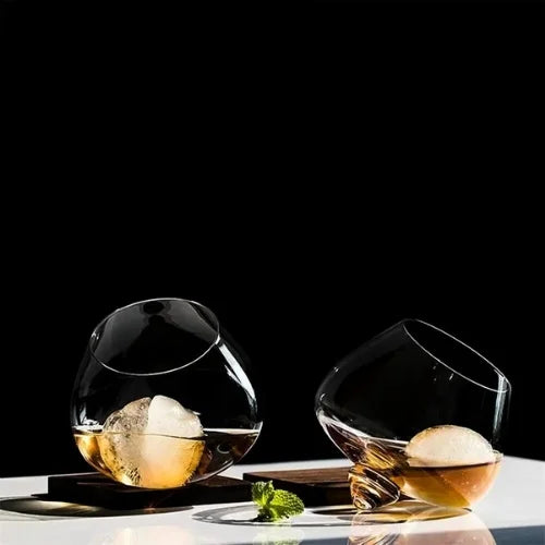 Paire de verres à whisky toupie sur une table, design innovant.